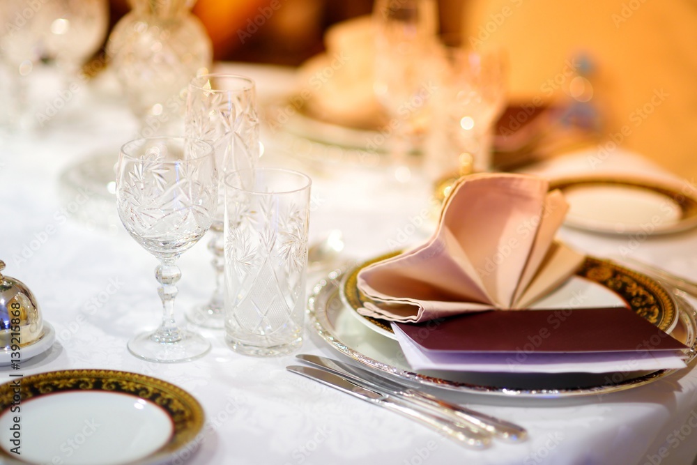 Beautiful table setting with crockery and flowers for a party, wedding reception or other festive event Beautiful table setting with crockery and flowers for a party, wedding reception or other festive event