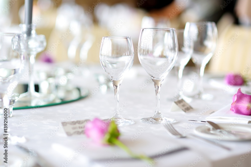 Beautiful table setting with crockery and flowers for a party, wedding reception or other festive event Beautiful table setting with crockery and flowers for a party, wedding reception or other festive event