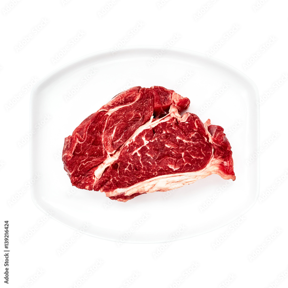 Raw beef steak on white plate isolated over white background