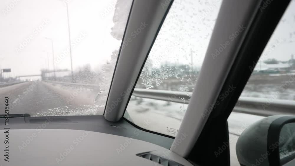 Driver's POV of driving on a highway on a winter day through a village; car interior, houses, road signs, a bridge and some highway traffic Driver's POV of driving on a highway on a winter day through a village; car interior, houses, road signs, a bridge and some highway traffic
