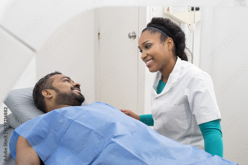 Medical Professional Preparing Man For X-ray Scan In Hospital Medical Professional Preparing Man For X-ray Scan In Hospital