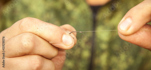 Foto the fisherman attaches the hook to the line, close-up