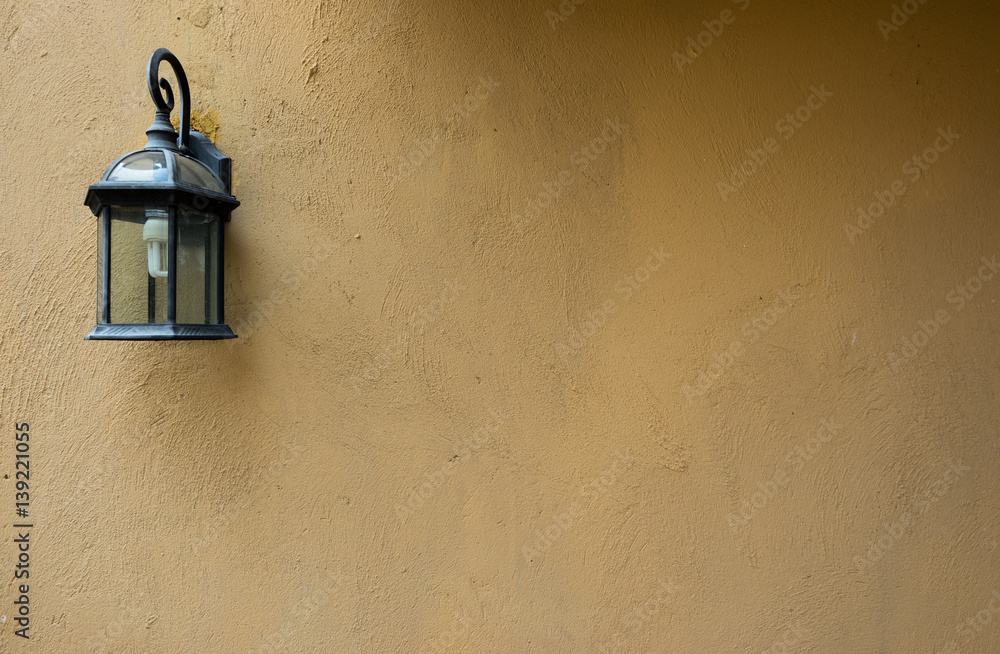 Brown raw concrete wall texture with old lamp useful as a background Brown raw concrete wall texture with old lamp useful as a background