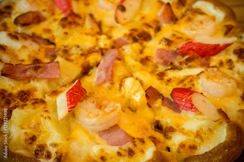 Pizza with a mixture of shrimp, crab, cheese, ham, pineapple.