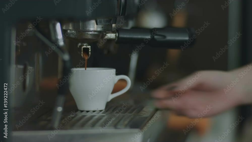 Coffee flows from the coffee machine in a mug in close-up Coffee flows from the coffee machine in a mug in close-up