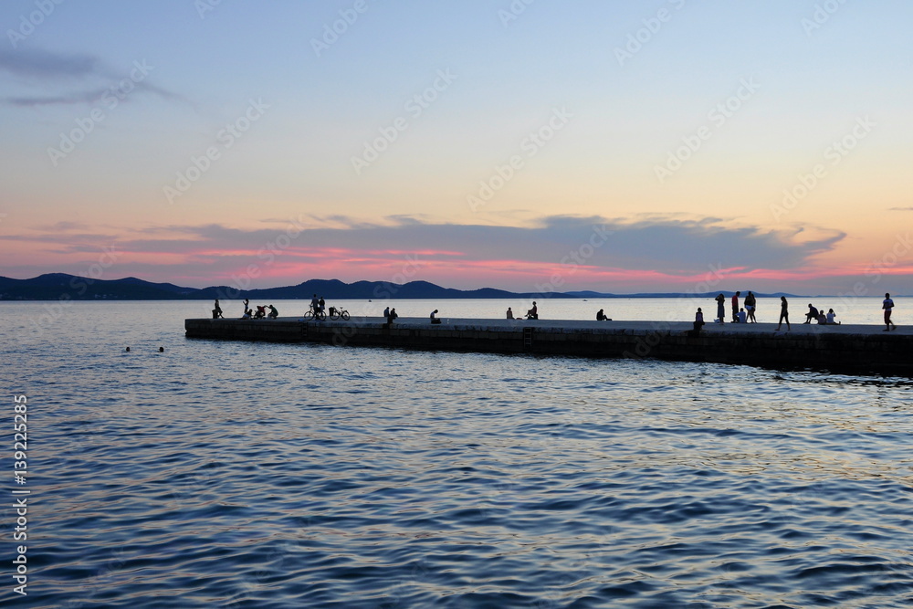  Idyll dusk. People relax on the pier near the shore of the Adriatic Sea. Croatia