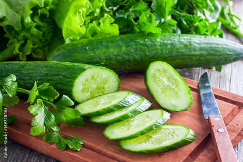 Fresh sliced green cucumber on a wooden board, horizontal