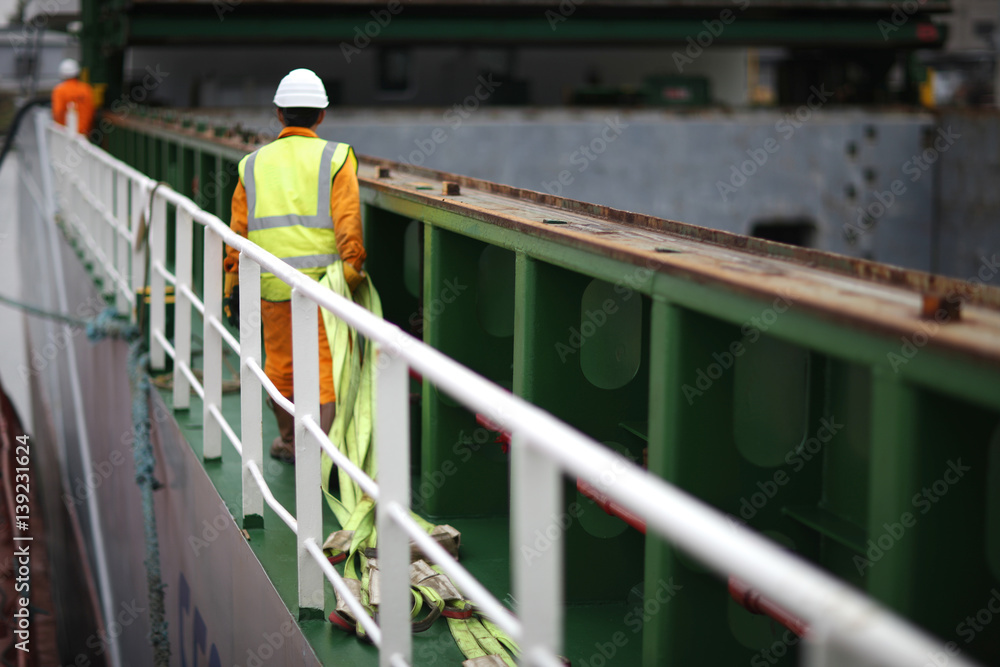 Port workers dragged slings for loading on board ship cargo ship Port workers dragged slings for loading on board ship cargo ship