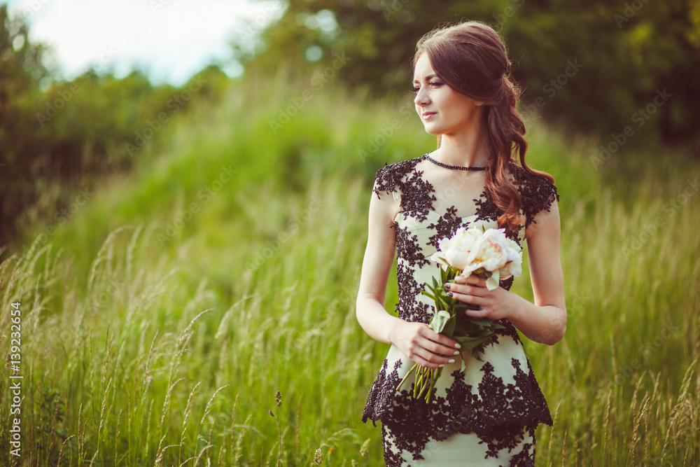 Beautiful young woman in dress with black laces holds bouquet of white peonies Beautiful young woman in dress with black laces holds bouquet of white peonies