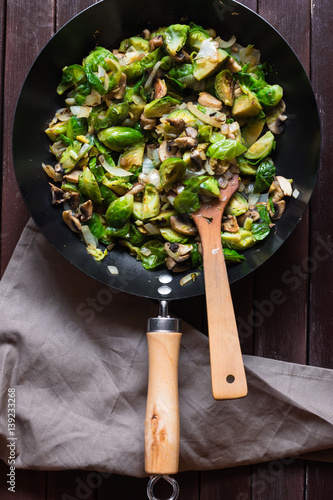 Billede på lærred Large skillet with sauteed brussels sprouts and mushrooms, mouth-watering, wood