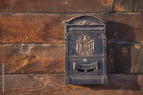 Old brown wooden wall. Iron mailbox