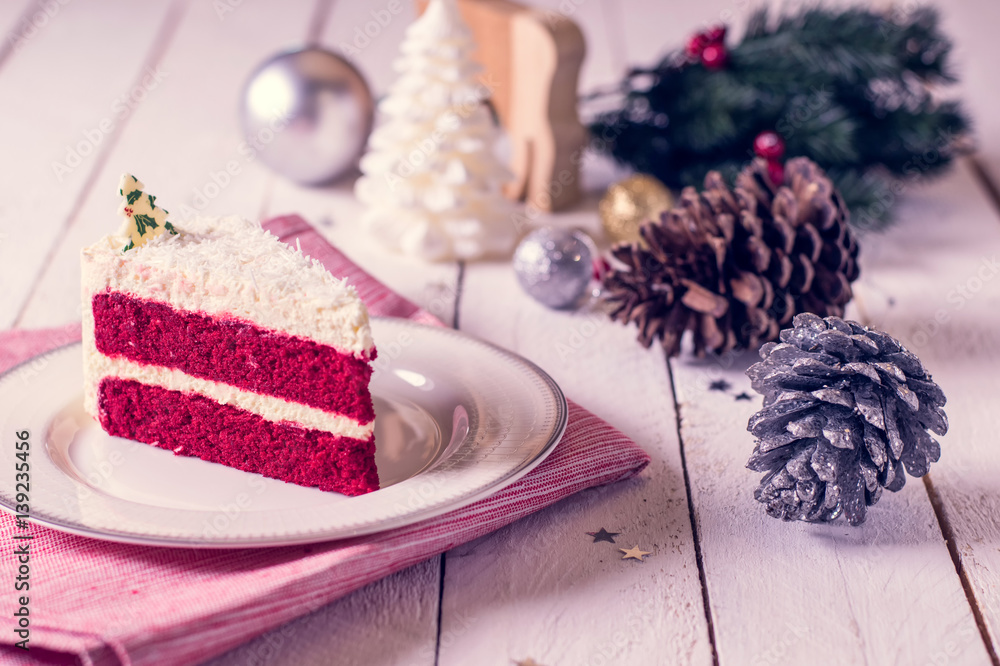Christmas cake on plate on red fabric on wood background and decorations Christmas cake on plate on red fabric on wood background and decorations