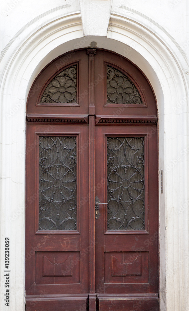Old vintage wooden brown door close-up with insertions and patterns on glass