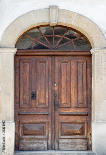 Old vintage wooden brown door close-up with insertions and patterns on glasspatterns on glass