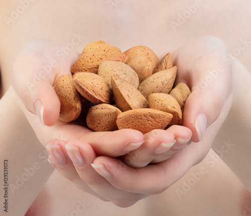 Obraz na plátně jeune femme tenant des amandes dans sa main