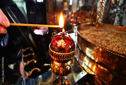 woman lights the candle at a greek Orthodox church 