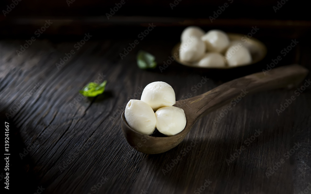 mini mozzarella and basil on a wooden background mini mozzarella and basil on a wooden background
