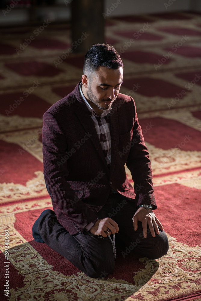 Obraz premium Humble Muslim praying while kneeling