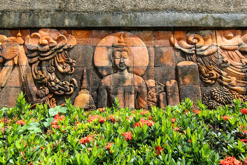 Thai sculpture in public park Buddha on wall
