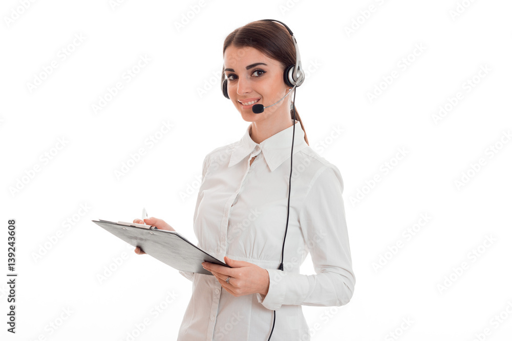 young girl in white shirt and headphones with microphone stands turning sideways and holding a Tablet young girl in white shirt and headphones with microphone stands turning sideways and holding a Tablet