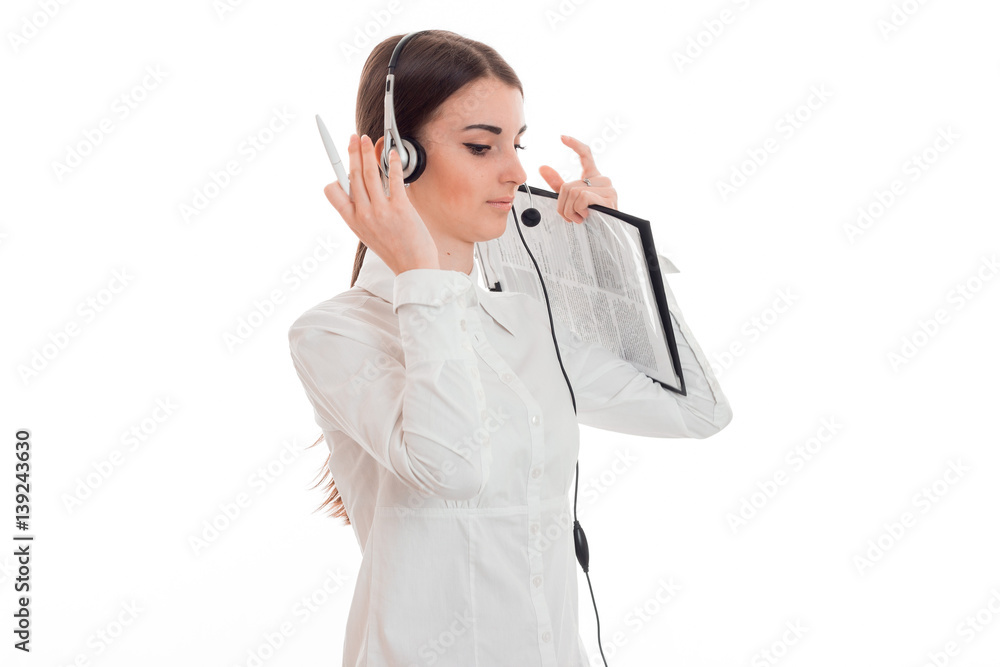 young girl in white shirt and headphones with microphone stands turning sideways and lifted her hands to head young girl in white shirt and headphones with microphone stands turning sideways and lifted her hands to head