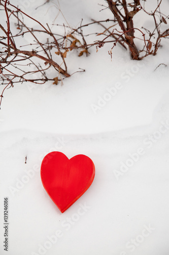 Red heart in the snow on a winter background. St. Valentine's Day