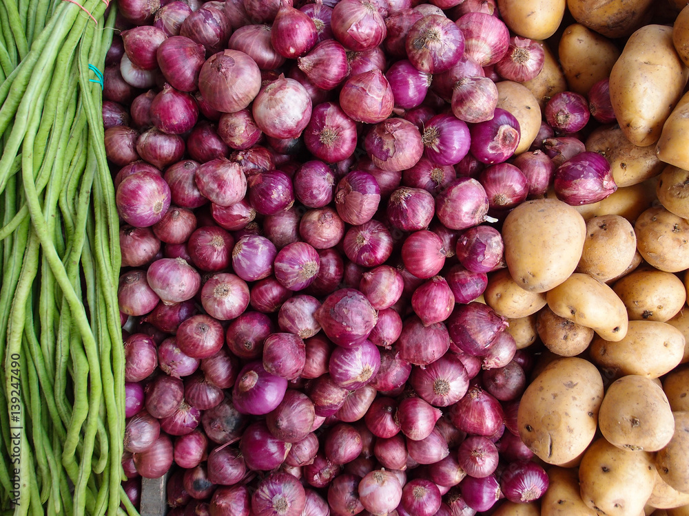 Potato, onion and beans on shop's display. Long beans, red onion and golden potato composition.