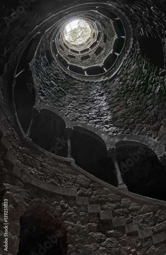 View upwards from the bottom of the Initiation well in Quinta da Regaleira. Unfinished Well. Inverted tower. photo