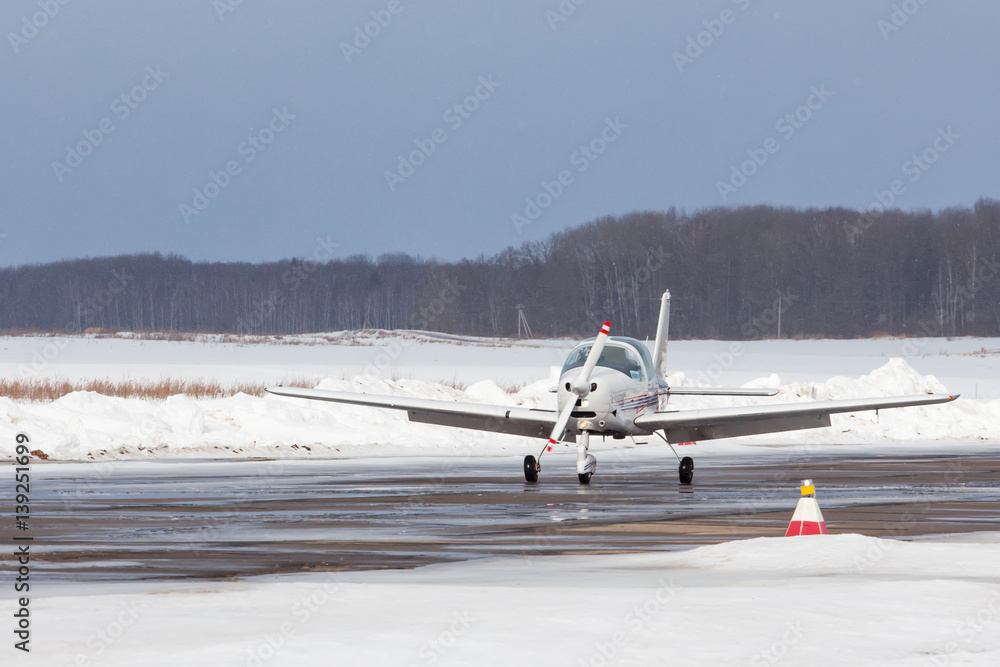 Small plane at the airport in winter Small plane at the airport in winter