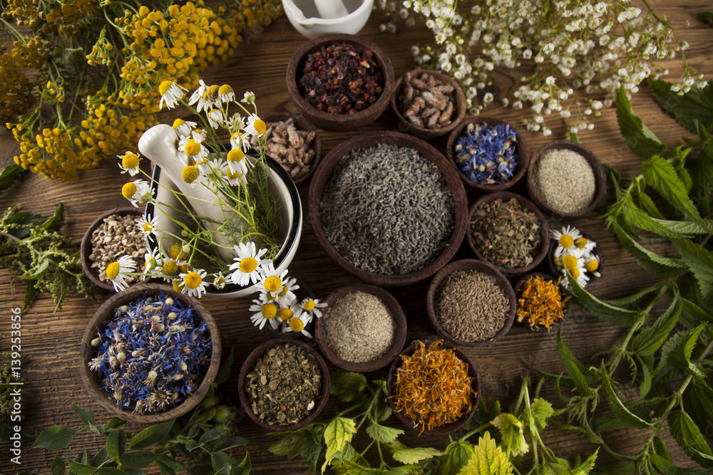 Alternative medicine, dried herbs and mortar on wooden desk background Alternative medicine, dried herbs and mortar on wooden desk background