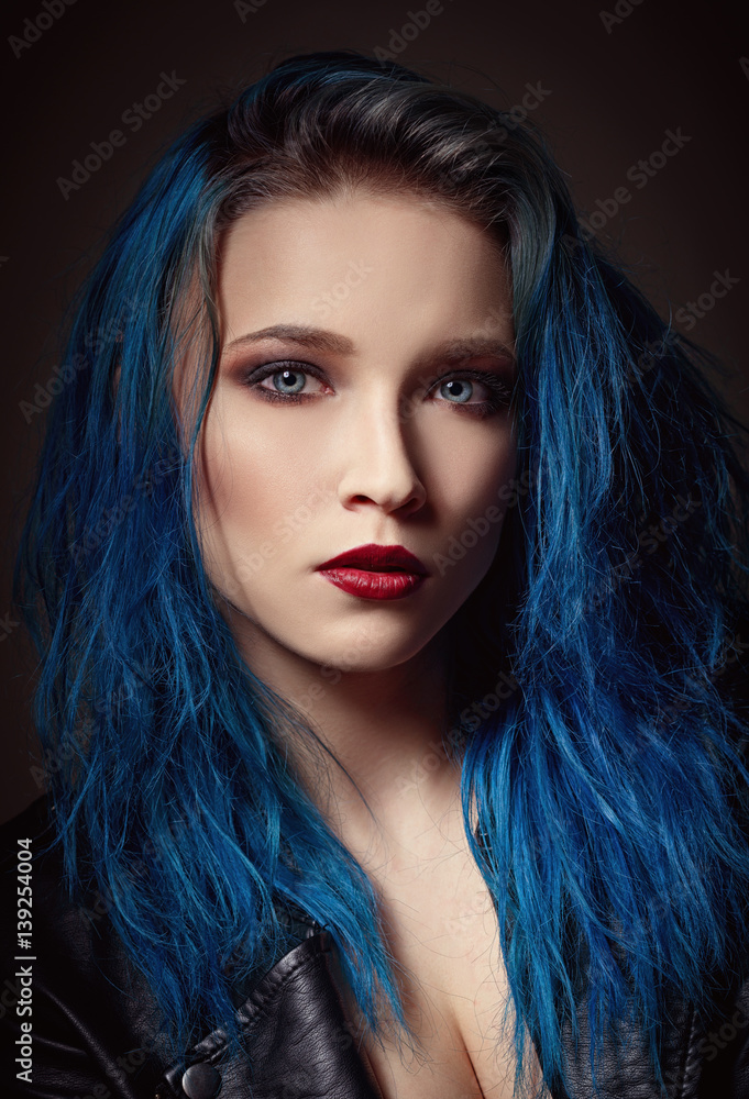 Closeup studio portrait of beautiful young woman with blue hair