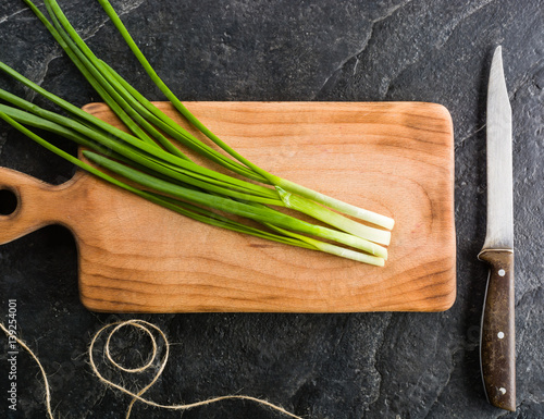 A bunch of green onions on a cutting board.