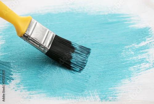 art brush puts a bright blue brush strokes on the surface of the white tree