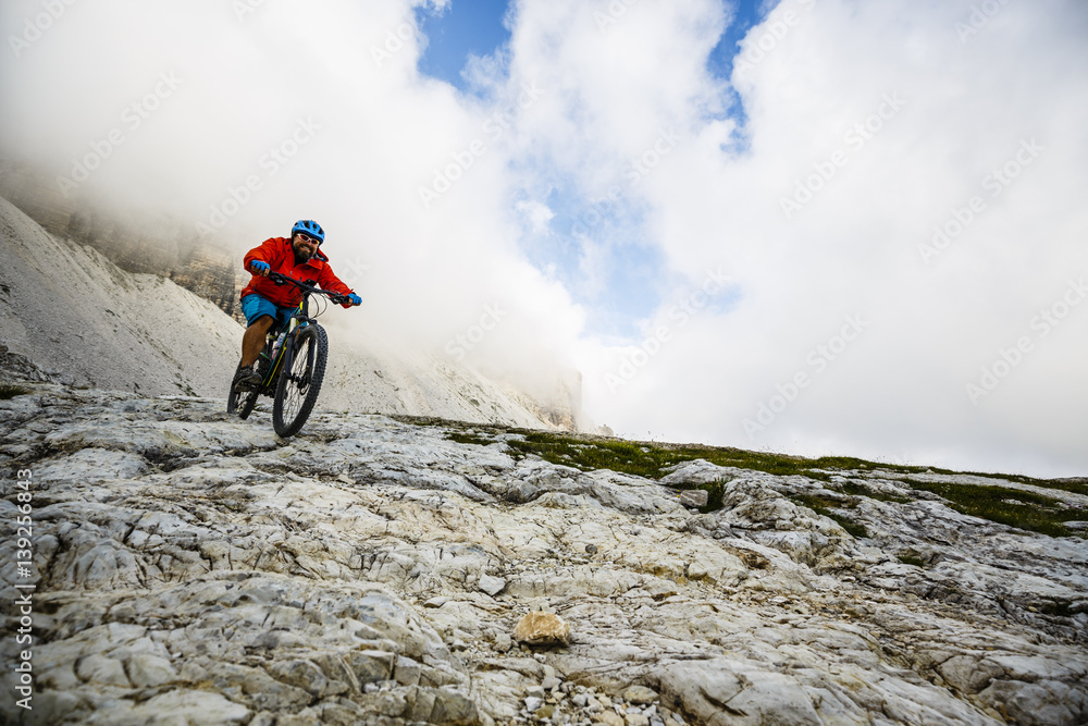 Obraz premium View of cyclist riding mountain bike on trail in Dolomites,Tre Cime di Laverado, South Tirol, Italy