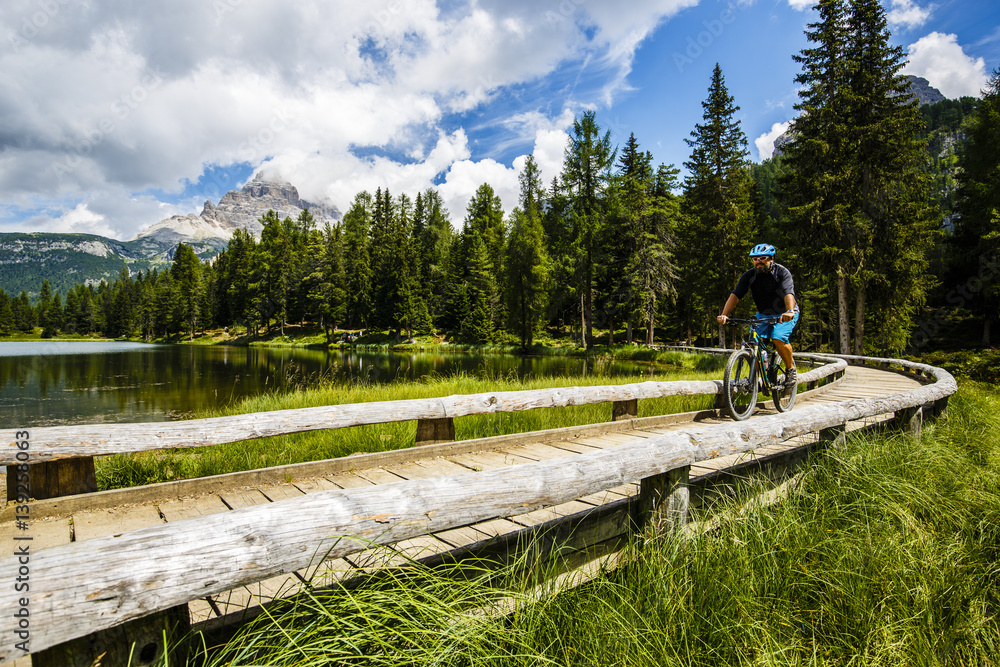 View of cyclist riding mountain bike on trail in Dolomites,Tre Cime di Laverado, South Tirol, Italy