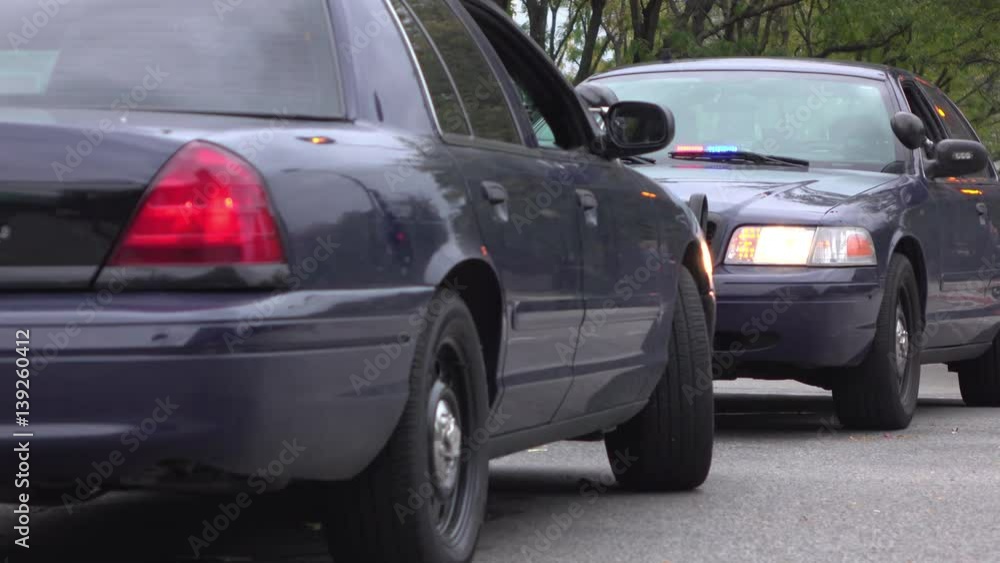 Lights of police vehicle flashing while blocking intersection.
Lights of police vehicle flashing while blocking intersection.