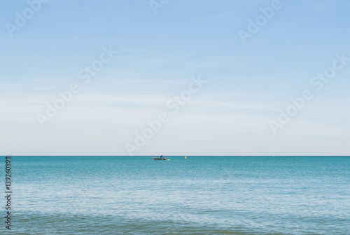 A lonely boat in the water of Mediterranean sea on sunny day at Malaga, Andalusia, Spain.