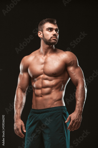 Strong Athletic Man - Fitness Model showing his perfect back isolated on black background with copyspace