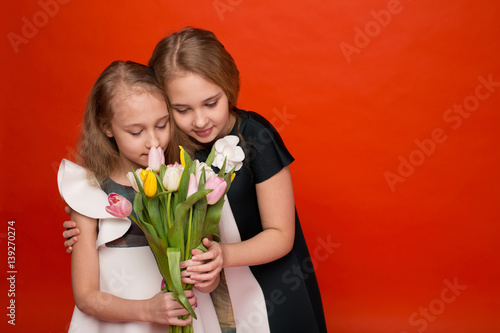 Two beautiful young girl with a bouquet of flowers