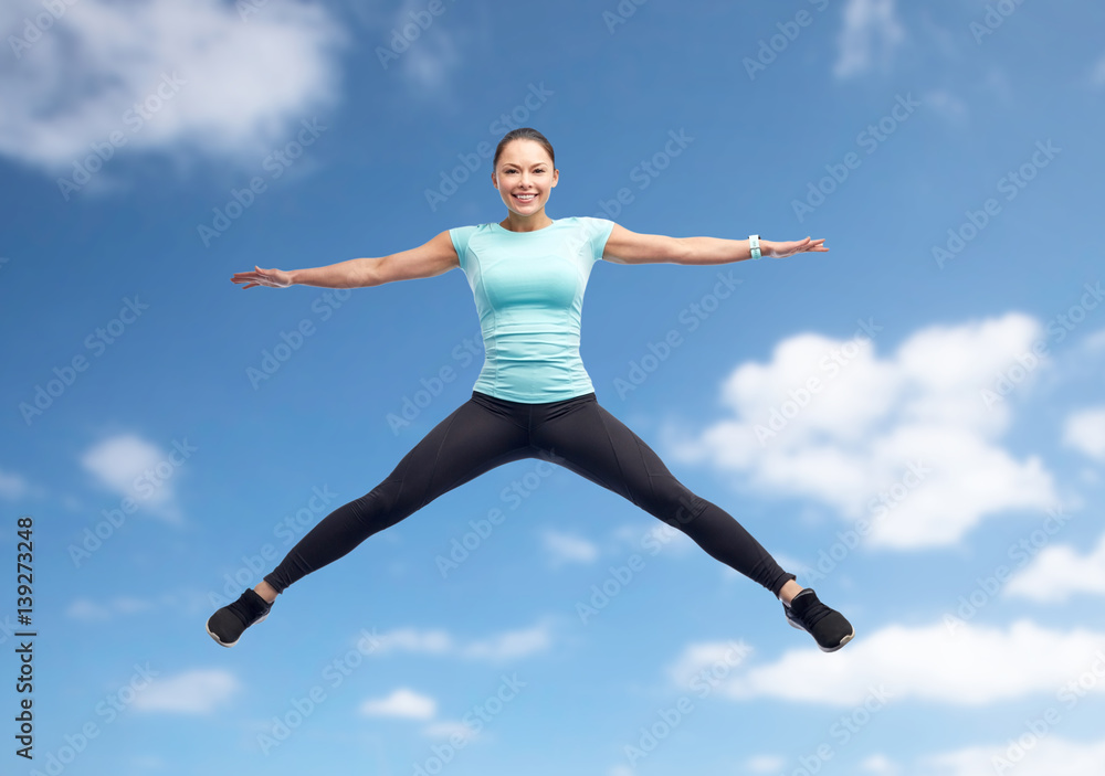 happy smiling sporty young woman jumping in air