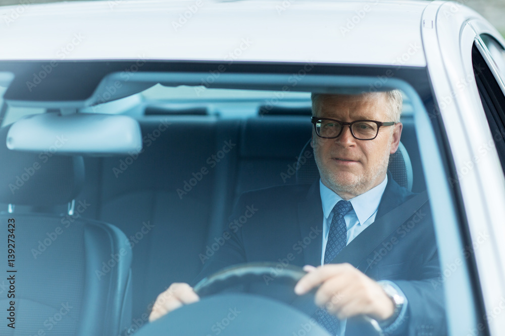 happy senior businessman driving car