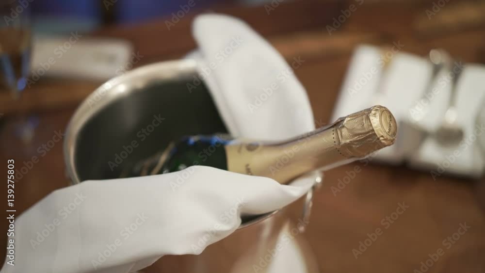 Young woman takes bottle of champagne from ice bucket indoors Young woman takes bottle of champagne from ice bucket indoors