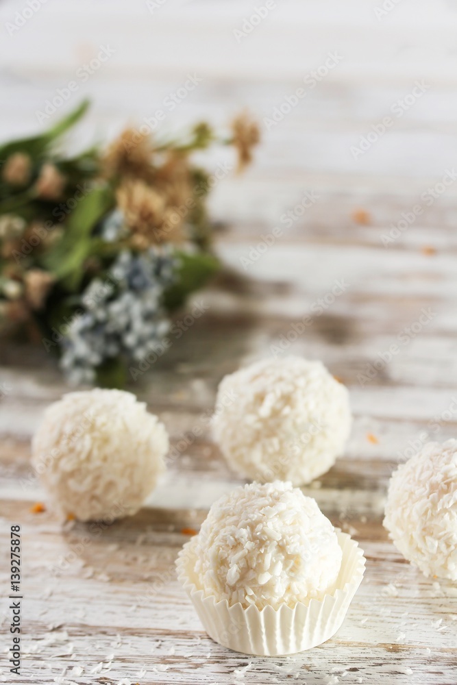 White Chocolate Coconut Truffles with spring flowers in background, selective focus White Chocolate Coconut Truffles with spring flowers in background, selective focus