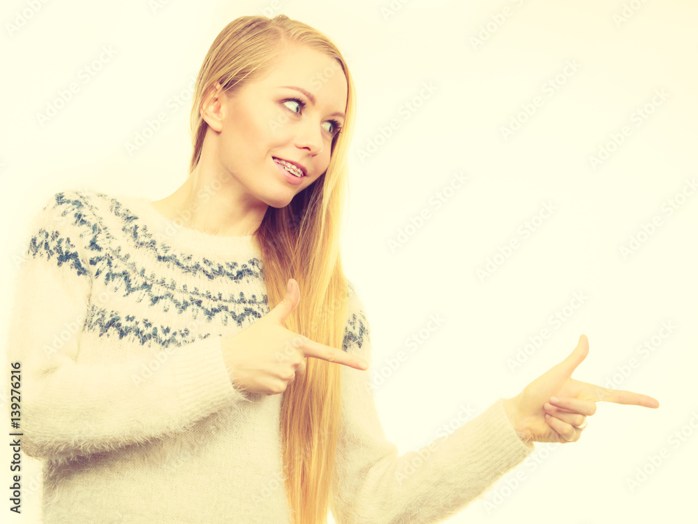 Teenage blonde woman pointing at copyspace Teenage blonde woman pointing at copyspace