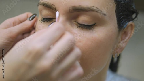 Young woman with hair in the paint, to eyebrow make-up sitting from the master image maker beauty salon ultra HD photo