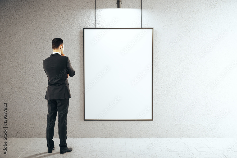 Man in interior with blank frame Man in interior with blank frame