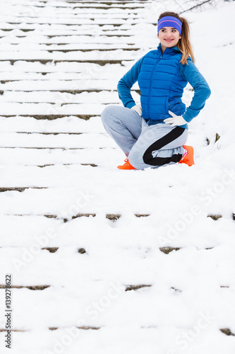 Woman wearing sportswear exercising outside during winter