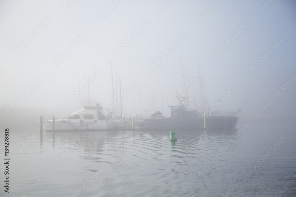 Boats in fog docked in morning sunrise at Monterey Bay in California Boats in fog docked in morning sunrise at Monterey Bay in California