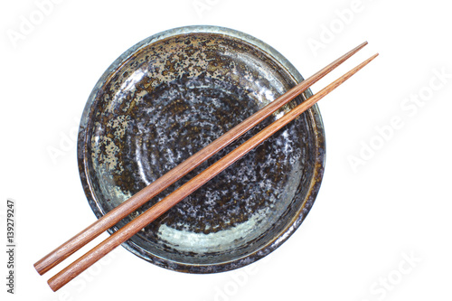 Black ceramic plate and wood chopstick on white background
