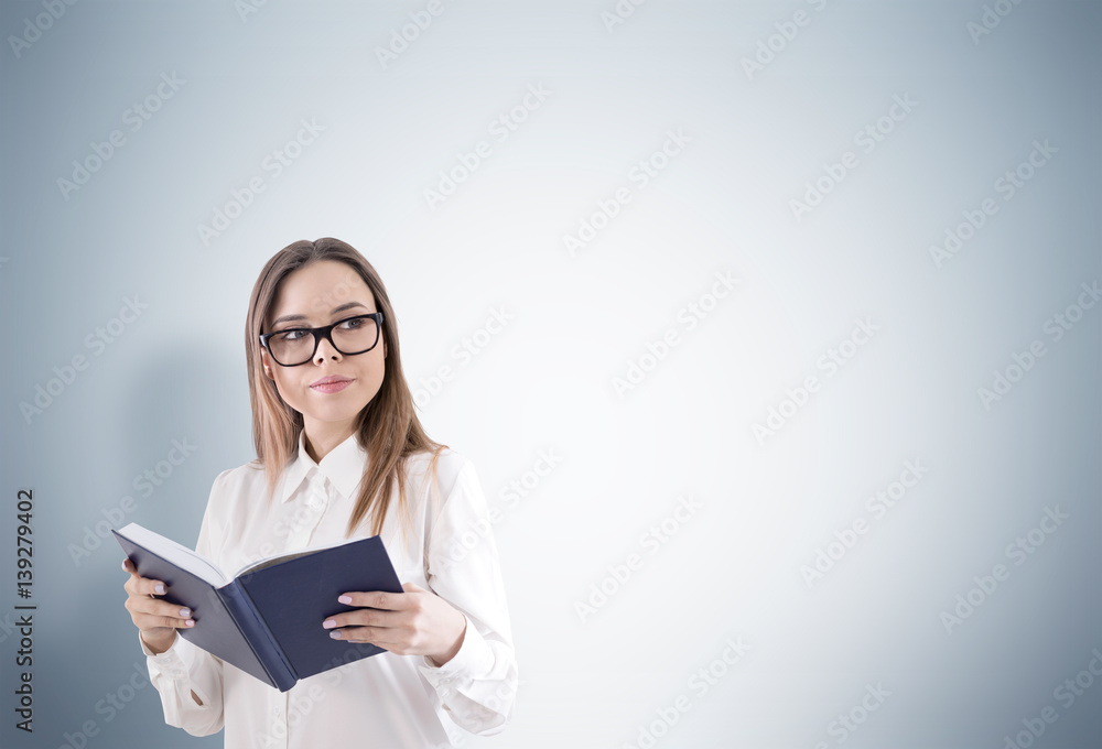 Smiling woman in glasses reading a book Smiling woman in glasses reading a book